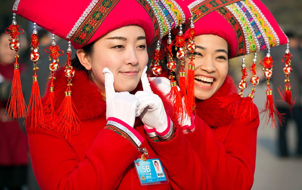 Hostesses pose for photos outside the Great Hall of the People during the opening session of the annual National People's Congress in Beijing.