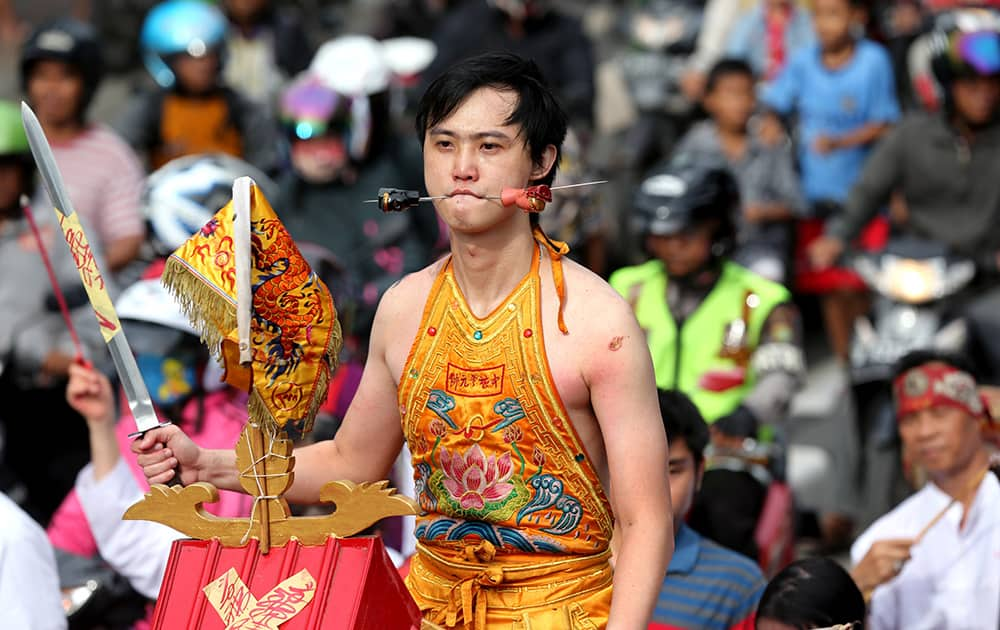 A worshipper gets his cheeks pierced with a metal skewer during Cap Go Meh festival that marks the end of the Lunar New year celebration, in Jakarta, Indonesia.