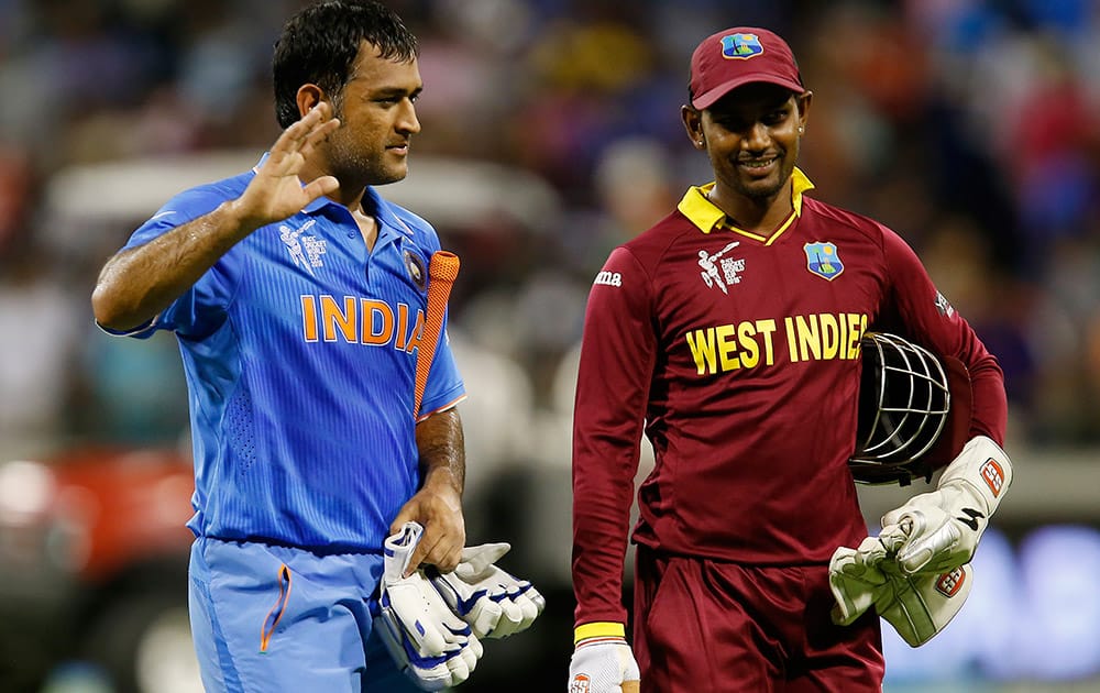 M S Dhoni waves to the crowd as he walks from the field with West Indies wicketkeeper Denesh Ramdin following their four wicket win in their Cricket World Cup Pool B match in Perth, Australia.