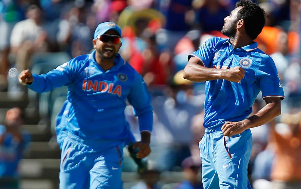 Mohammed Shami celebrates with his teammate M S Dhoni after dismissing West Indies batsman Dwayne Smith during their Cricket World Cup Pool B match in Perth, Australia.