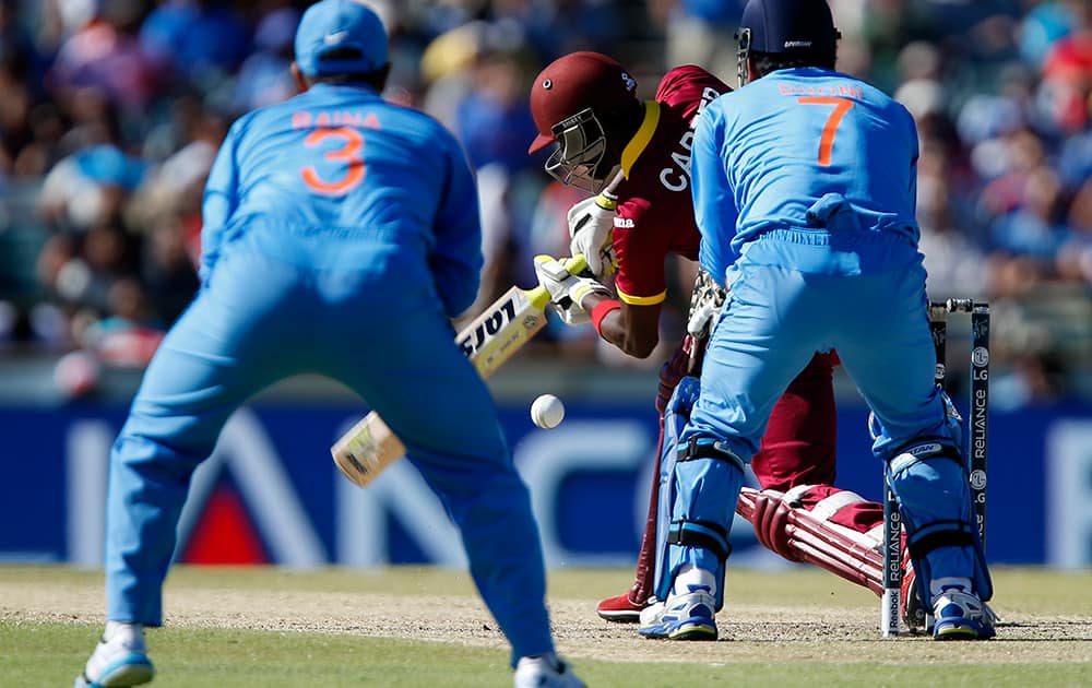 West Indies batsman Jonathan Carter hits the ball as Indian fielder's Suresh Raina and M S Dhoni watch during their Cricket World Cup Pool B match in Perth, Australia.