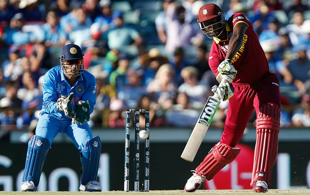 West Indies batsman Jason Holder hist the ball as Indian wicketkeeper M S Dhoni watches during their Cricket World Cup Pool B match in Perth, Australia.