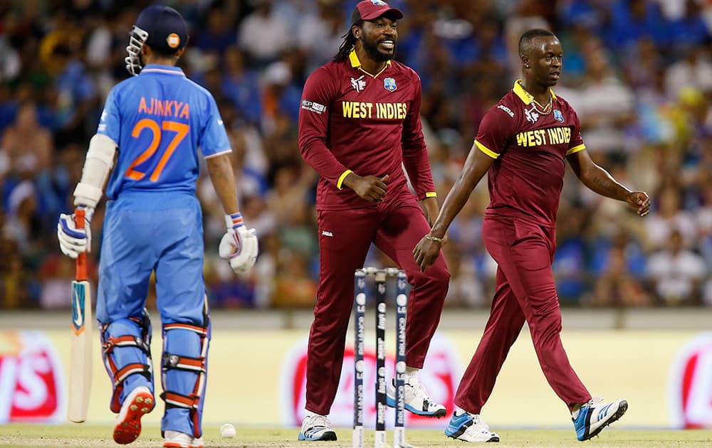 West Indies bowler Kemar Roach celebrates with teammate Chris Gayle after dismissing Indian batsman Ajinkya Rahane during their Cricket World Cup Pool B match in Perth, Australia.