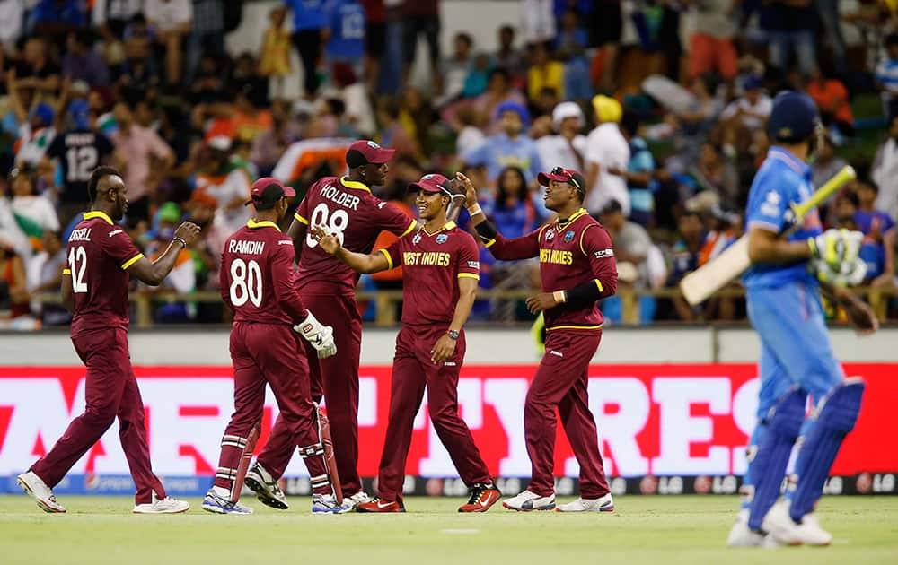 West Indies fieldsman Marlon Samuels is congratulated by teammates after taking a catch to dismiss India's Ravindra Jadeja during their Cricket World Cup Pool B match in Perth, Australia.