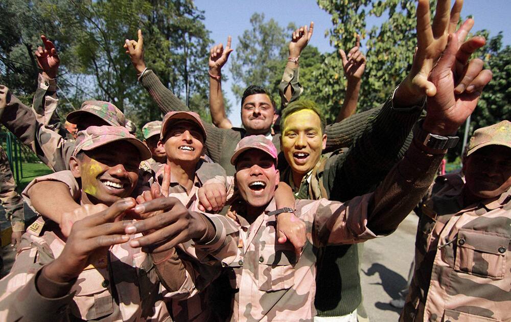 Border Security Force (BSF) soldiers dance as they celebrate Holi festival at Paloura in Jammu.