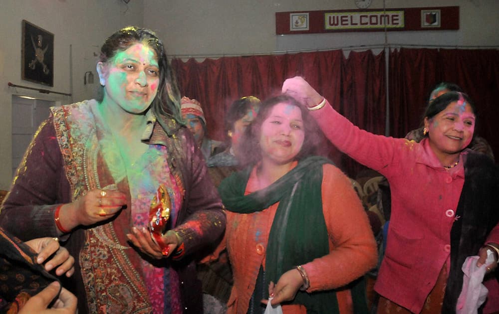 Family members of Border Security Force (BSF) soldiers celebrate the Holi festival at their headquarter in Srinagar.