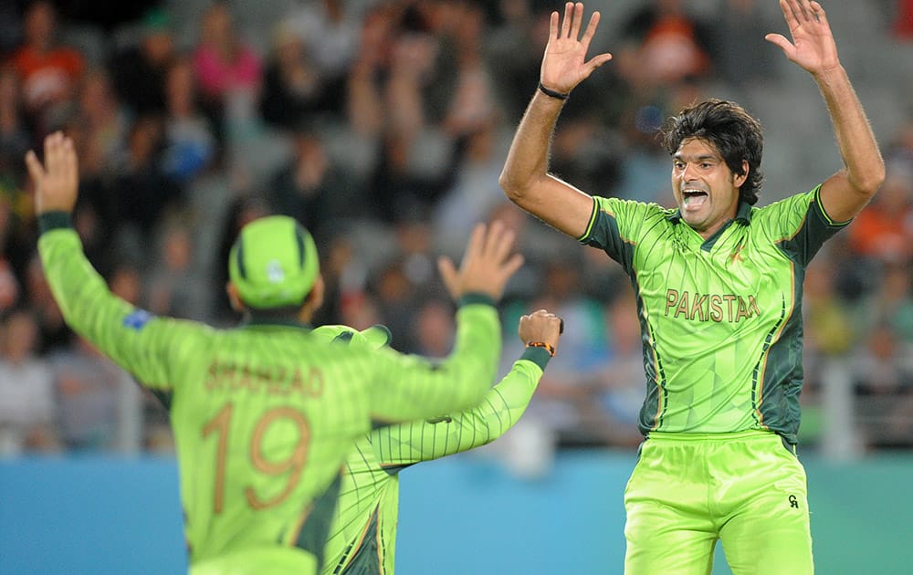 Pakistan bowler Mohammad Irfan celebrates with teammates Umar Akmal and Ahmad Shahzad after taking the wicket of South African batsman J.P. Duminy during their Cricket World Cup Pool B match in Auckland, New Zealand.