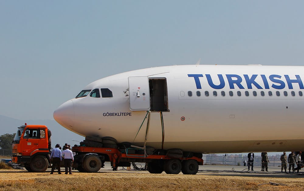 The front body of a Turkish Airlines jet that skidded is loaded onto a truck at Tribhuwan International Airport in Kathmandu, Nepal. According to airport officials, Nepal's only international airport is expected to open Saturday evening as workers attempted to remove the jet that skidded after landing Wednesday morning, blocking the single runway, aviation officials said Friday.