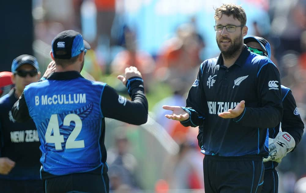 New Zealand bowler Dan Vettori, right, is congratulated by his captain Brendon McCullum after he bowled Afghanistan batsman Usman Ghani for no score during their Cricket World Cup Pool A match in Napier, New Zealand.