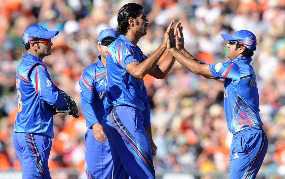 Afghanistan bowler Shapoor Zadran, centre, is congratulated by teammates after dismissing New Zealand’s Kane Williamson during their Cricket World Cup Pool A match in Napier, New Zealand.