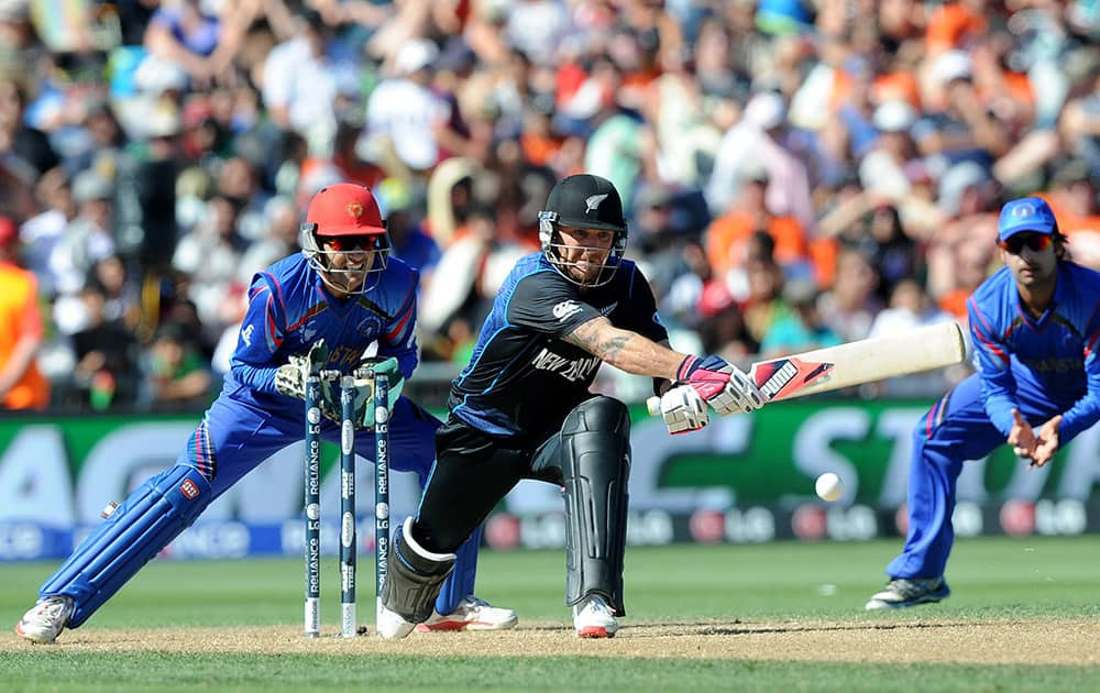 New Zealand batsman Brendon McCullum plays a reverse sweep shot as Afghanistan wicketkeeper Afsar Zazai, left, watches during their Cricket World Cup Pool A match in Napier, New Zealand.