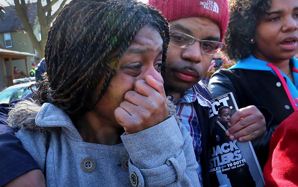 Kyrisha Isom, left, weeps with Derrick McCann during a rally protesting the shooting death of Tony Robinson, in Madison, Wis. 