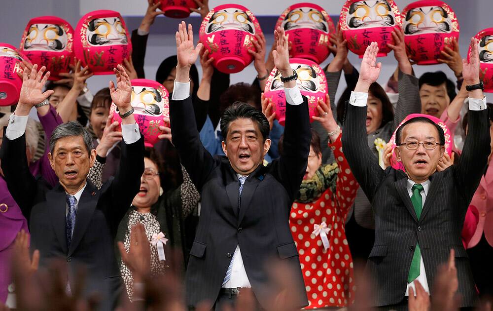 Japan's Prime Minister Shinzo Abe, center, and his Liberal Democratic Party members shout traditional 