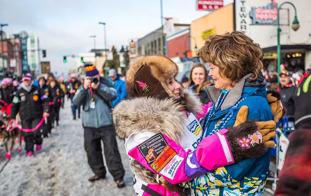 Musher DeeDee Jonrowe, left, gets a hug from Sen. Lisa Murkowski before the ceremonial start of the Iditarod Trail Sled Dog Race, in Anchorage, Alaska.