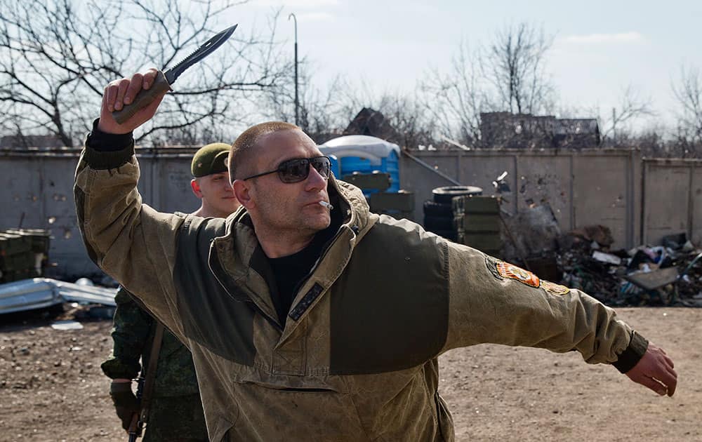 A Russia-backed rebel shows off knife throwing skills at the most forward front line base, as the sound of sporadic shelling, automatic weapons and sniper fire could be heard, on the outskirts of Donetsk, Ukraine.