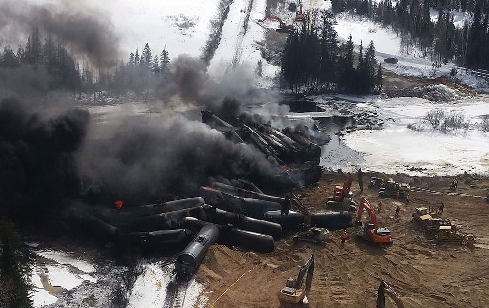 In this photo provided by Glenn Thibeault, smoke rises from a CN Rail train derailment near Gogama, Ontario.  A CN Rail train carrying crude oil derailed Saturday causing numerous tank cars to catch fire and spill into a local river system, officials said. 