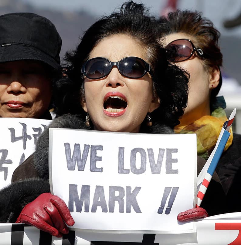 A woman holds a sign during a rally denouncing the attack on U.S. Ambassador to South Korea Mark Lippert in downtown Seoul, South Korea.