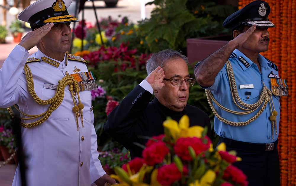 India's President Pranab Mukherjee, center, Chief of Naval Staff R.K. Dhowan, left, and Air Force chief Marshal Arup Raha salute as they par homage at the India Gate war memorial, in New Delhi, India.