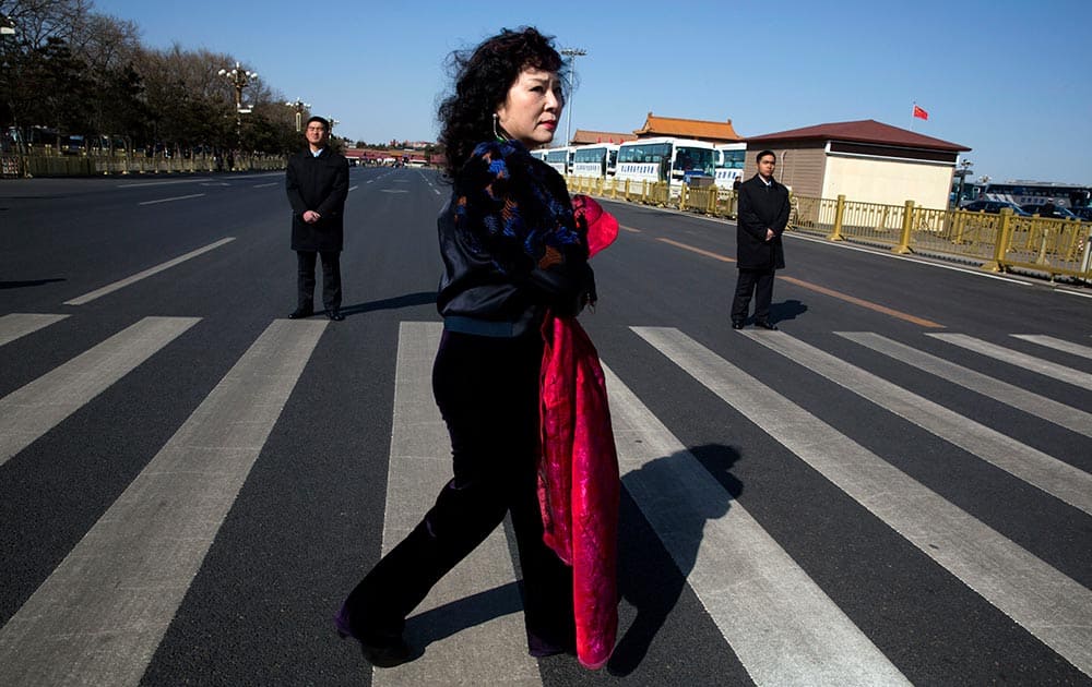 A delegate walks near security personnel near the Great Hall of the People before a plenary session of the Chinese People's Political Consultative Conference in Beijing.