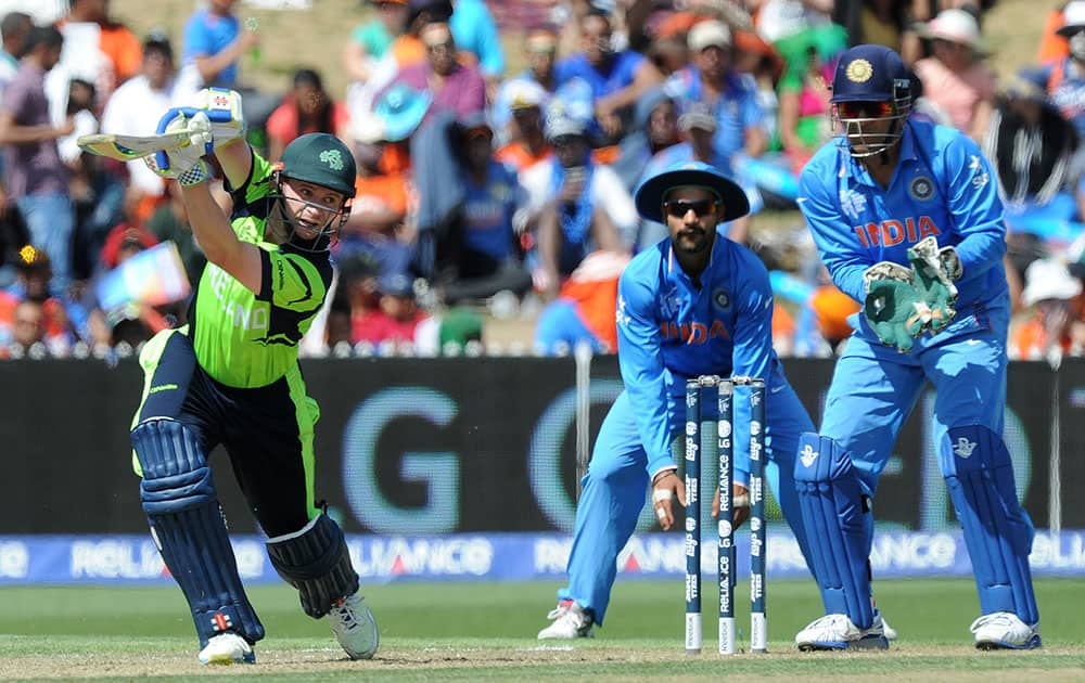 Ireland's William Portfield plays a shot as Indian wicketkeeper MS Dhoni, right, watches during their Cricket World Cup Pool B match in Hamilton, New Zealand.