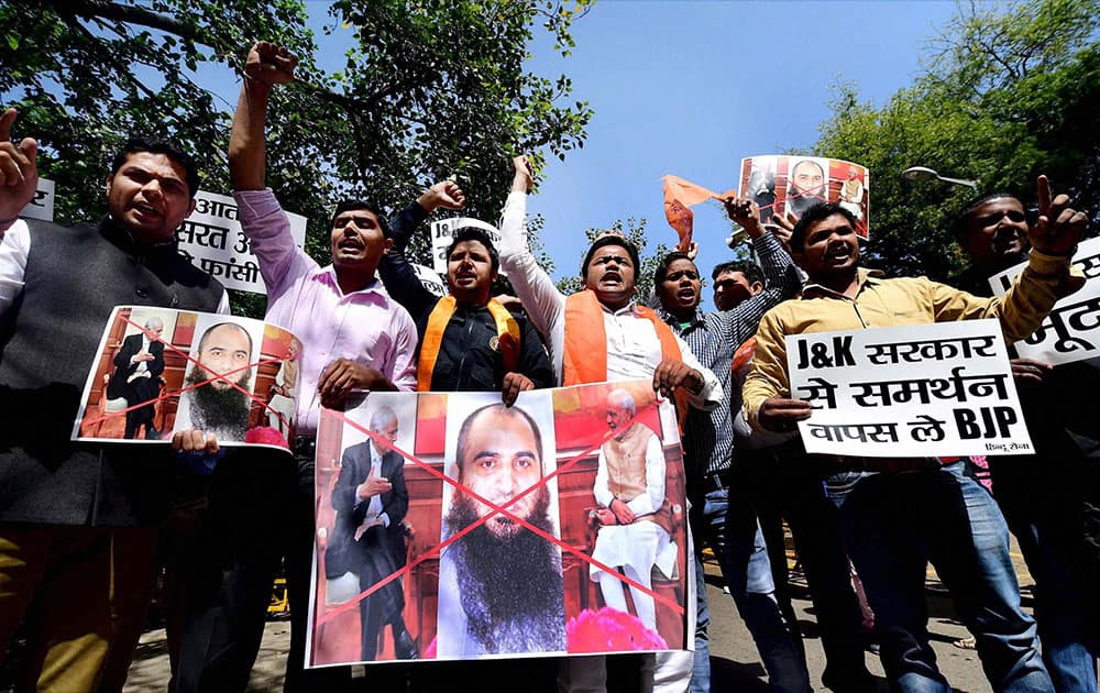 Activists of Hindu Sena showing a picture from a meeting of Prime Minster Narendra Modi and Jammu and Kahsmir Chief Minister Mufti Mohammad Sayeed along with the separatist leader Masarat Alam during a protrest in New Delhi.