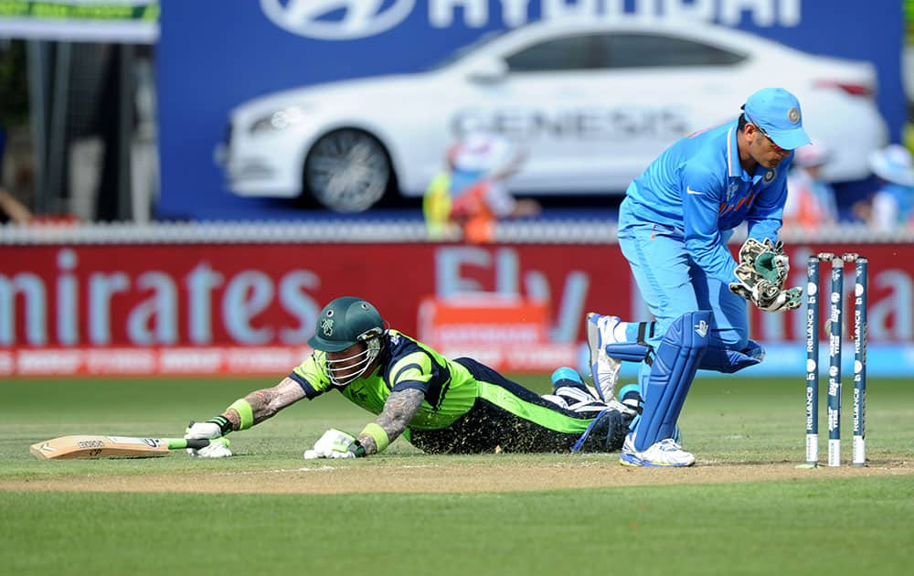 Ireland's John Mooney dives to make his ground as India's wicketkeeper MS Dhoni takes the ball during their Cricket World Cup Pool B match in Hamilton, New Zealand.