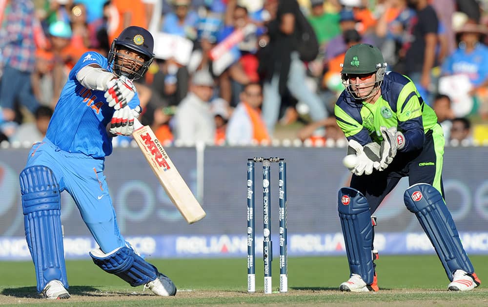 Indian batsman Shikhar Dhawan plays a shot as Ireland's wicketkeeper Gary Wilson watches during their Cricket World Cup Pool B match in Hamilton, New Zealand.