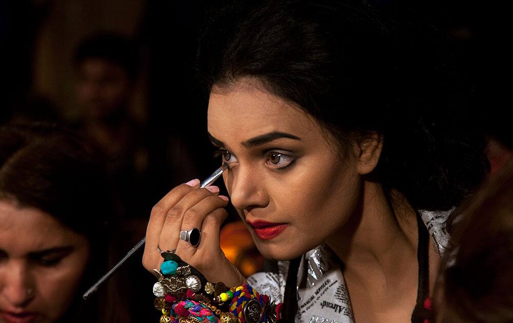 A Pakistani model gets ready backstage to present designers creations during South Asian Fashion Exhibition 2015 in Karachi, Pakistan.