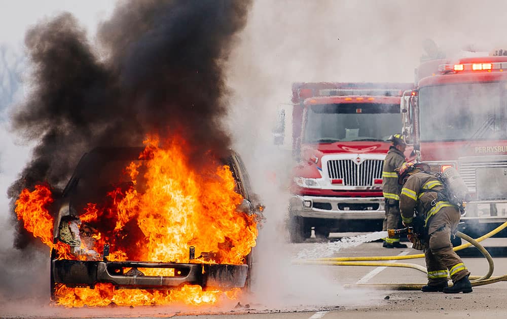 Firefighters from Perrysburg Township work to put out a vehicle fire in the northbound lane of Interstate 75 just south of Perrysburg, Ohio.