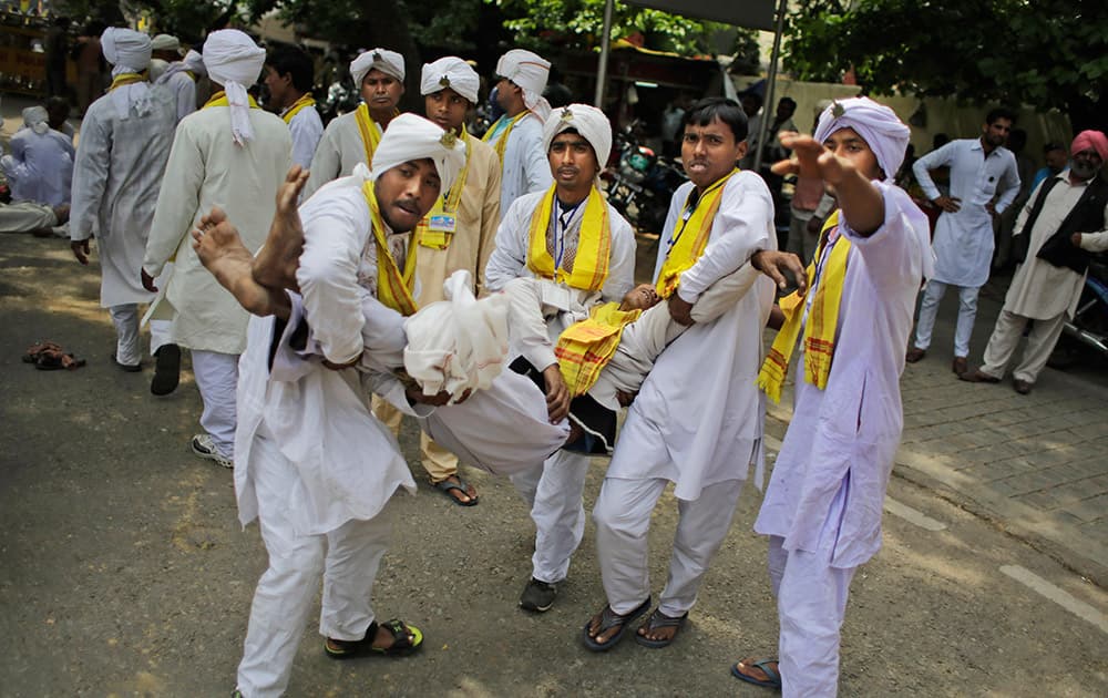 Members of India’s indigenous Rajbanshi community from the north eastern West Bengal state carry one among their group who fainted during a mass hunger strike near the Indian Parliament in New Delhi. The protestors were demanding a separate state of Cooch Behar.