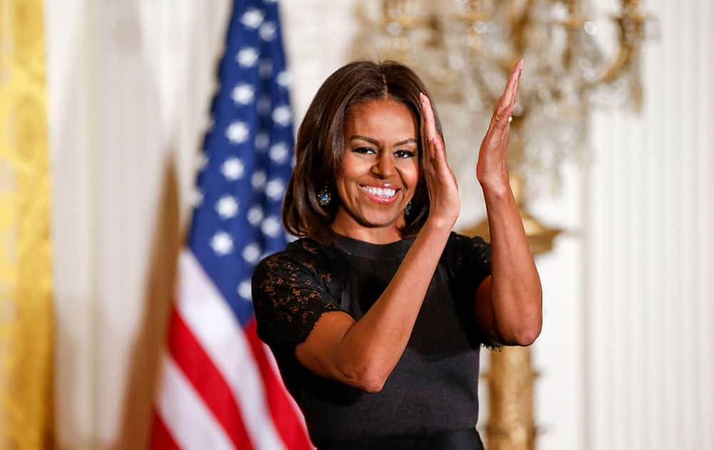 First lady Michelle Obama claps after speaking at an event to mark Nowruz, in the East Room of the White House in Washington. 