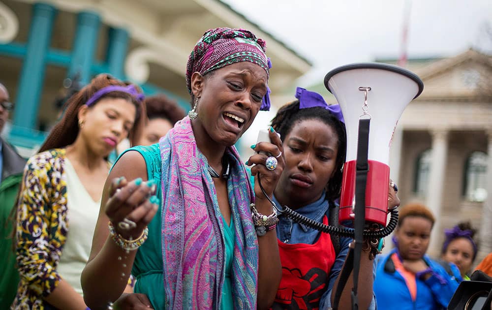 Omega Menders cries as she speaks to protesters demonstrating the shooting death of 27-year-old Anthony Hill by a police officer, in Decatur, Ga. 