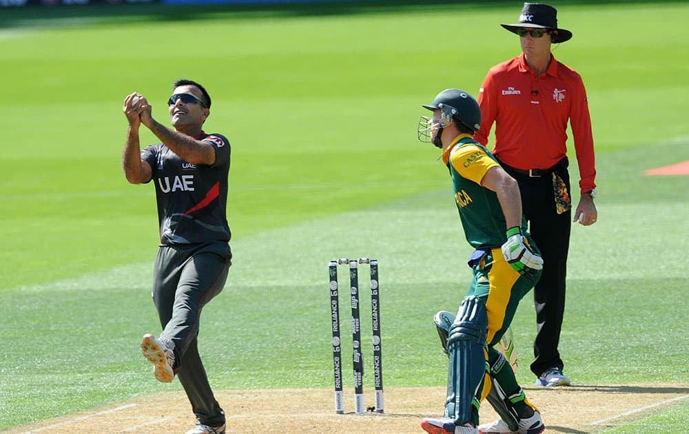 United Arab Emirates bowler Mohamed Tauqir, left, takes a catch to dismiss Rilee Rossouw as South African captain A.B de Villiers, right, watches during their Cricket World Cup Pool B match in Wellington, New Zealand.