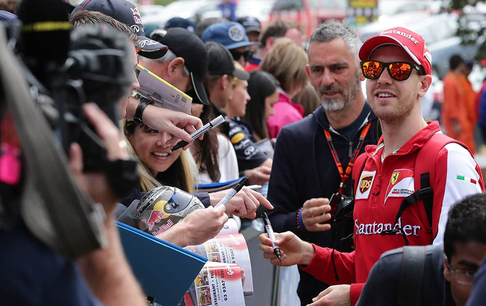 Ferrari driver Sebastian Vettel of Germany looks towards fans as he signs autographs ahead of the Australian Formula One Grand Prix at Albert Park in Melbourne, Australia.