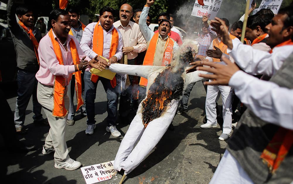 Activists of Shiv Sena party shout slogans as they burn an effigy of Mufti Mohammed Sayeed, Chief Minister of Jammu and Kashmir state, in New Delhi.