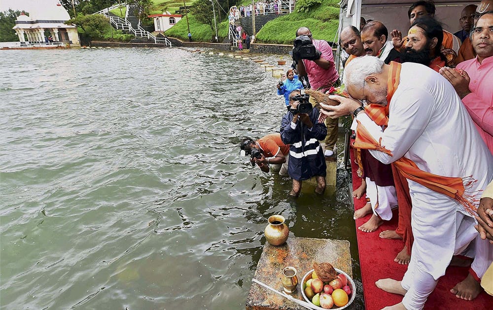 Prime Minister Narendra Modi prays after pouring Ganga water into a sacred pond in Mauritius.