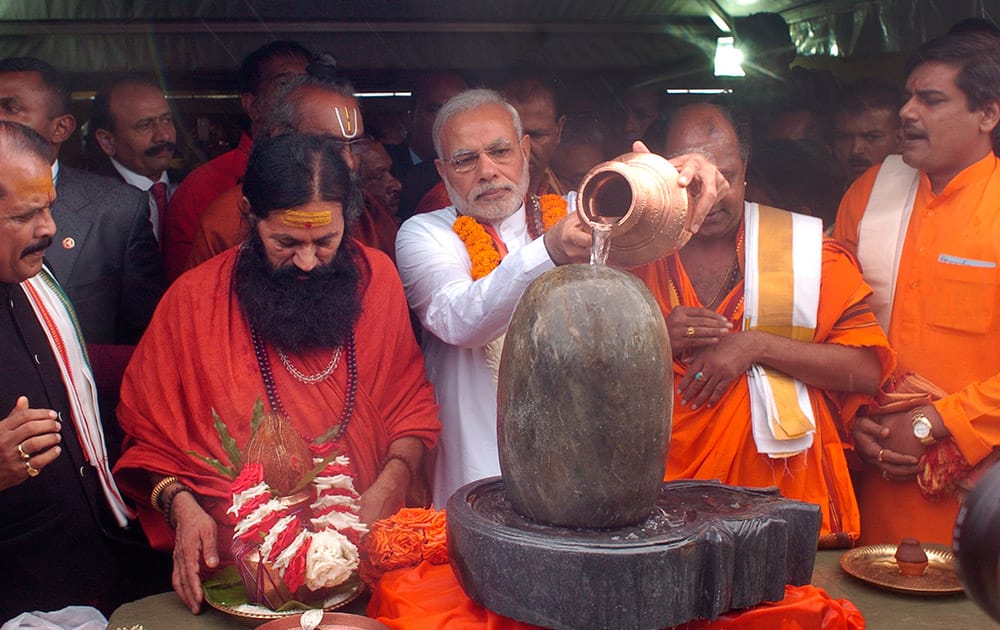 PM Narendra Modi, pours holy water on a lingam or shivling, a representation of the Hindu deity Shiva used for worship, during a Hindu religious ceremony at the crater lake of Grand Bassin (also known as Ganga Talao), during the second day of his visit to the Republic of Mauritius.