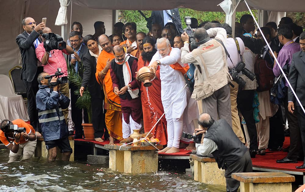 Prime Minister Narendra Modi, empties a container of holy water into the crater lake of Grand Bassin (also known as Ganga Talao) as part of a Hindu religious ceremony during the second day of his visit to the Republic of Mauritius.