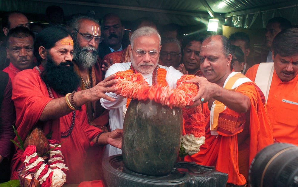 Prime Minister Narendra Modi, places flowers on a lingam or shivling, a representation of the Hindu deity Shiva used for worship, during a Hindu religious ceremony at the crater lake of Grand Bassin (also known as Ganga Talao), during the second day of his visit to the Republic of Mauritius.