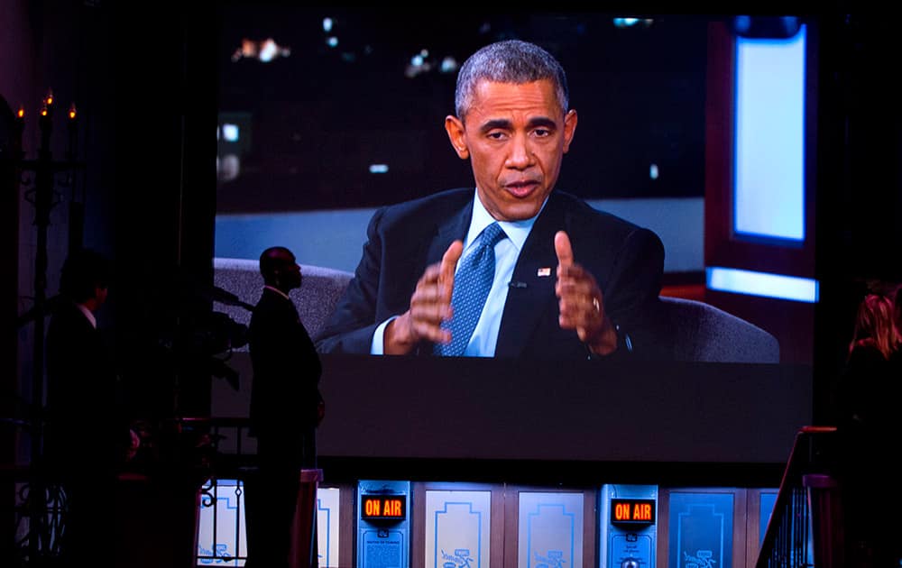 A Secret Service Agent stands by a screen showing a live feed as President Barack Obama talks with Jimmy Kimmel while they are taped on Jimmy Kimmel Live, in Los Angeles.