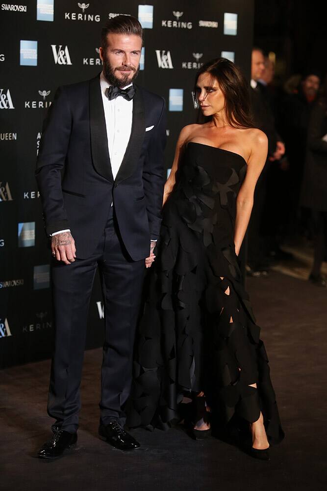 Former soccer player David Beckham and his wife, designer Victoria Beckham pose for photographers upon arrival at the Alexander McQueen Savage Beauty Gala exhibition in London.