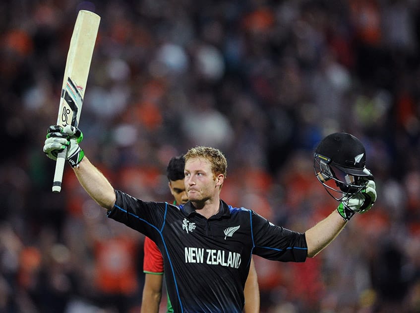 New Zealand’s Martin Guptill waves his bat as he celebrates after scoring a century while batting against Bangladesh during their Cricket World Cup Pool A match in Hamilton, New Zealand.