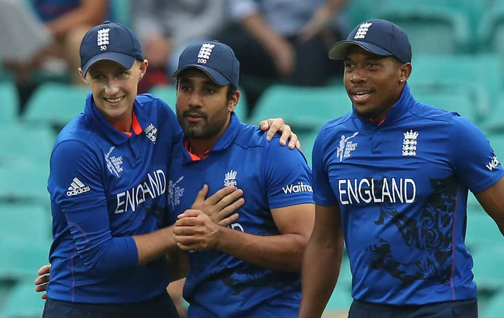 England's Chris Jordan, right, and Joe Root congratulate teammate Ravi Bopara, center, for the dismissal of Afghanistan's Shafiqullah during their Cricket World Cup pool A match in Sydney.