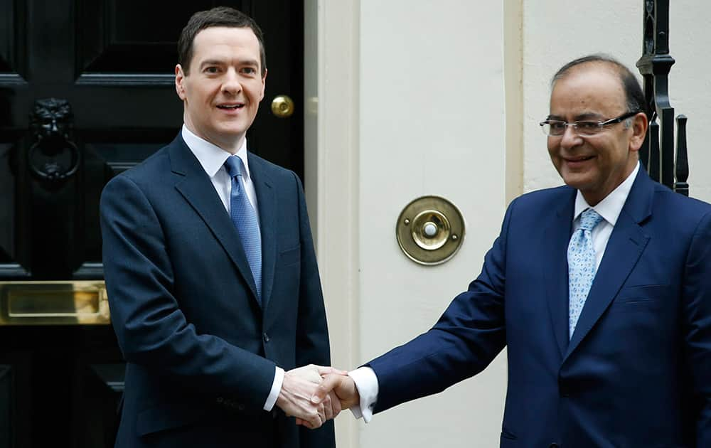 Britain's Chancellor of the Exchequer George Osborne greets the Indian Finance Minister Arun Jaitley on the doorstep of 11 Downing Street in London.