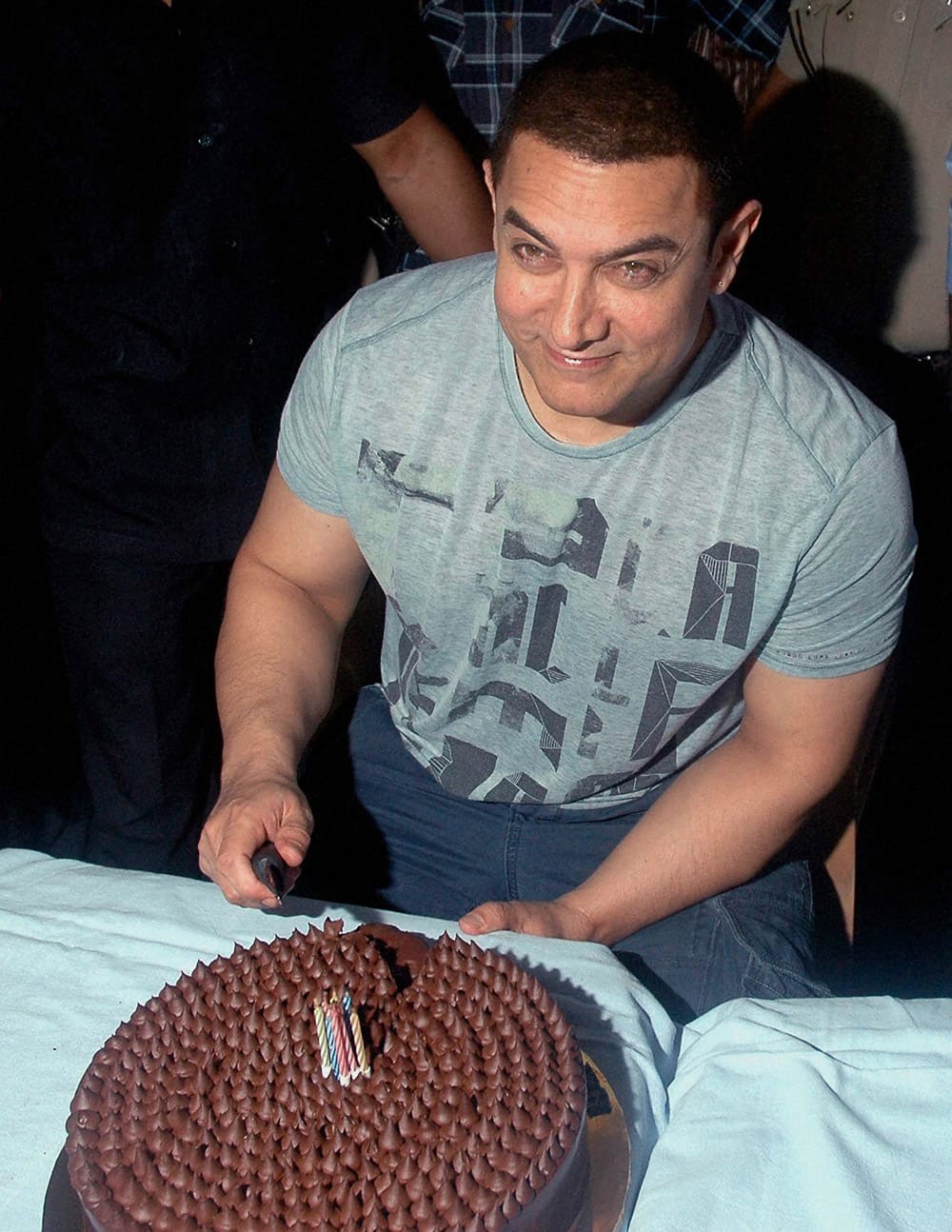 Aamir Khan cuts a cake to celebrate his 50th birthday at his residence in Mumbai.