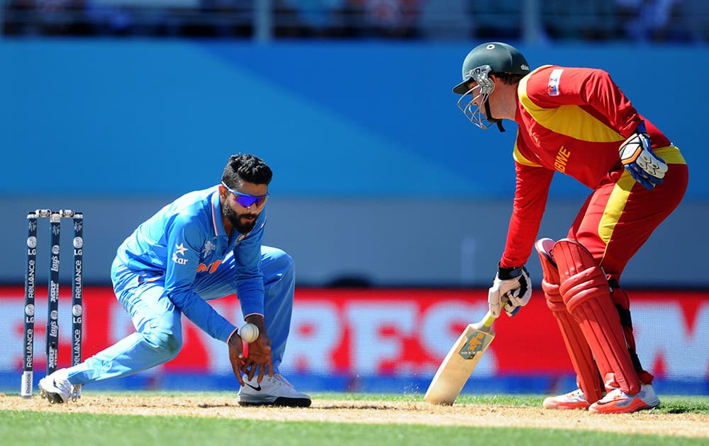 Ravindra Jadeja fields the ball as Zimbabwe batsman Brendan Taylor, right, watches during their Cricket World Cup Pool B match in Auckland, New Zealand