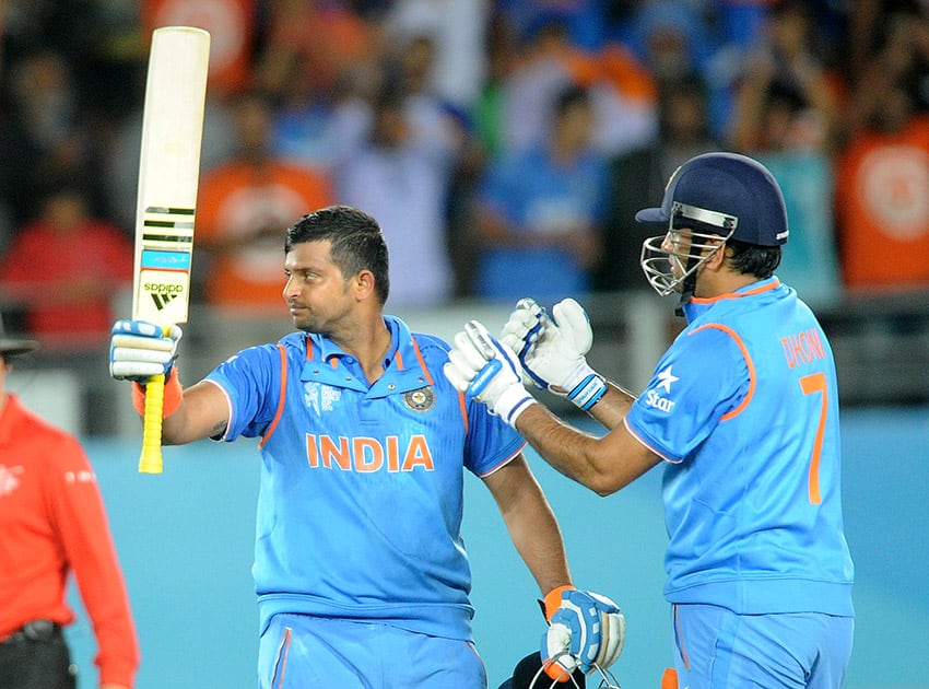 Suresh Raina waves his bat as his captain MS Dhoni watches after scoring a century while batting against Zimbabwe during their Cricket World Cup Pool B match in Auckland, New Zealand.