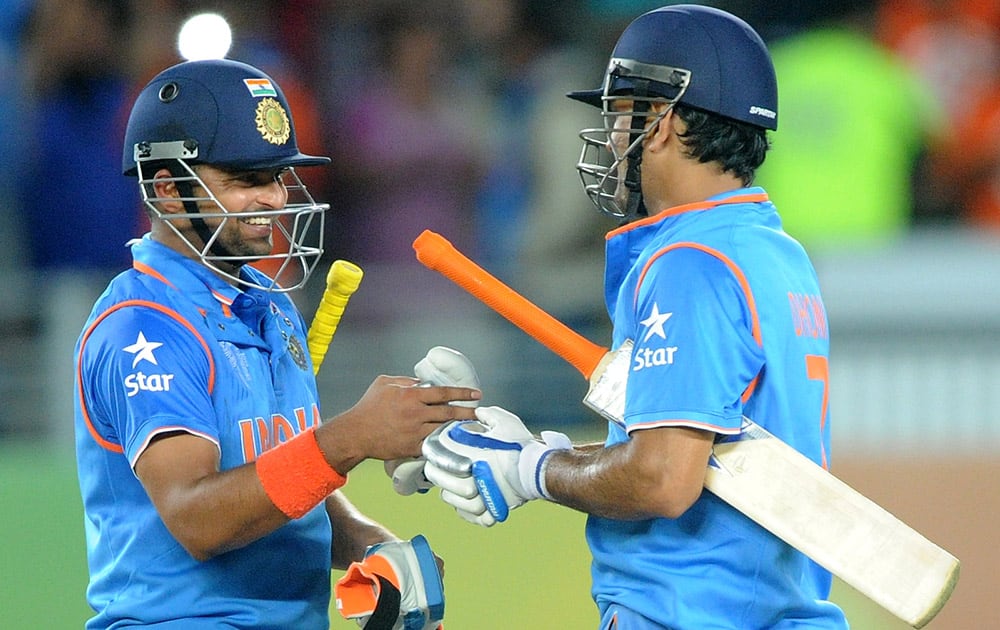 Suresh Raina and his captain MS Dhoni celebrate after they defeated Zimbabwe by six wickets to win their Cricket World Cup Pool B match in Auckland, New Zealand