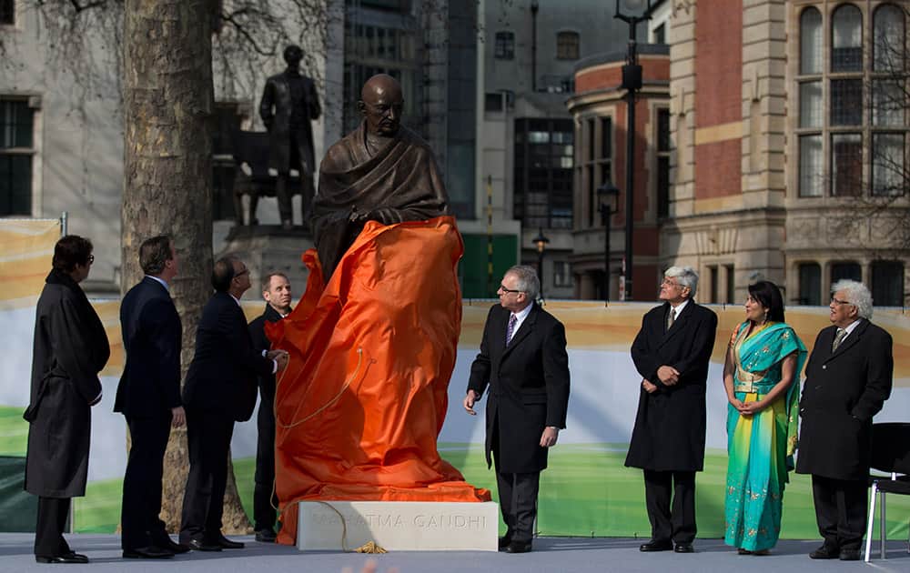 A new statue of Mahatma Gandhi by British sculptor Philip Jackson is unveiled by India's Finance Minister Arun Jaitley, watched by, Amitabh Bachchan, British Prime Minister David Cameron and Gandhi's grandson Gopalkrishna Gandhi, in Parliament Square, London.