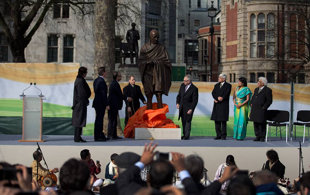 A new statue of Mahatma Gandhi by British sculptor Philip Jackson is unveiled by India's Finance Minister Arun Jaitley, watched by, Amitabh Bachchan, British Prime Minister David Cameron and Gandhi's grandson Gopalkrishna Gandhi, in Parliament Square, London.